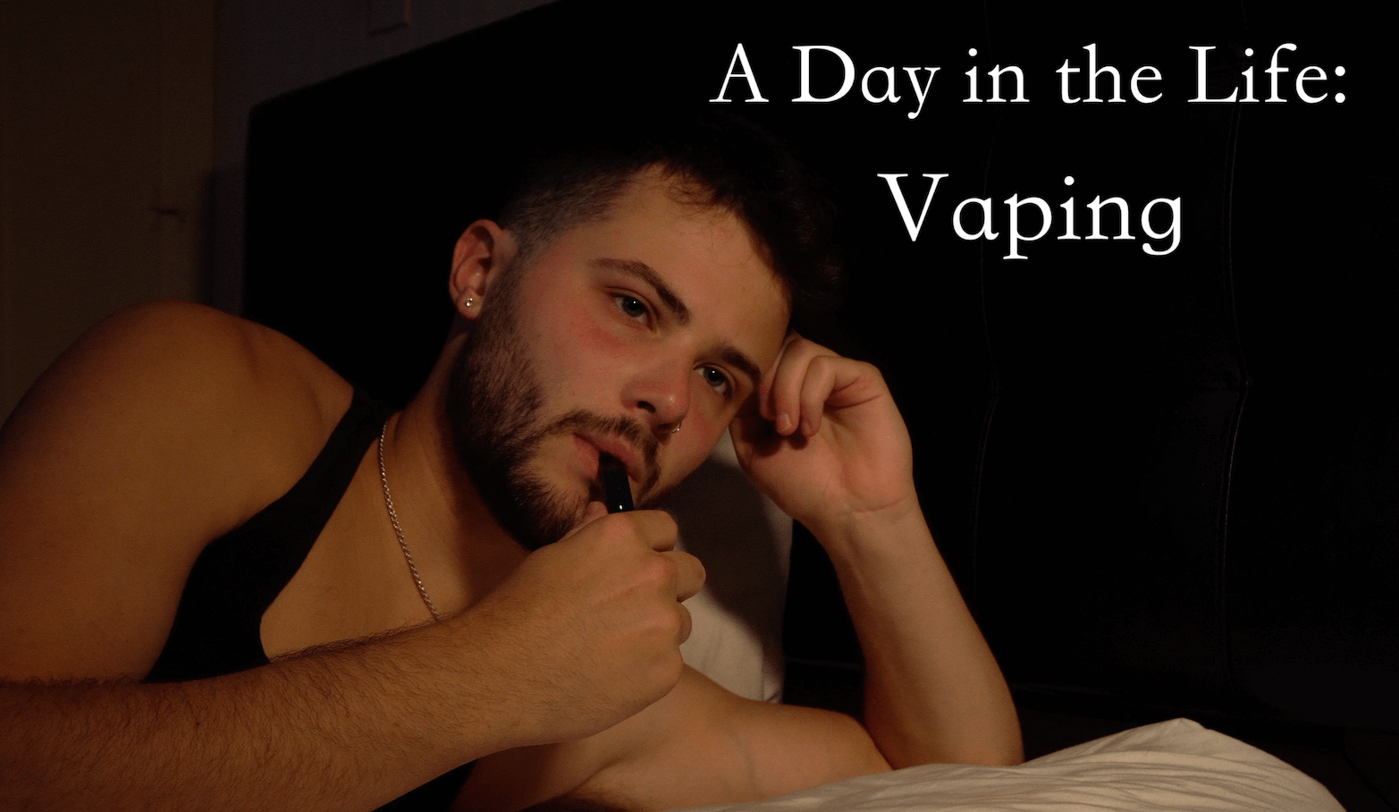 A Day in the life Vaping. A Man in a tank top with his vape up to his lips.